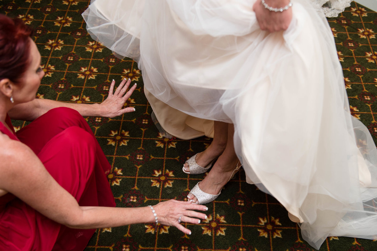 bridesmaid waves hands over shoes picture