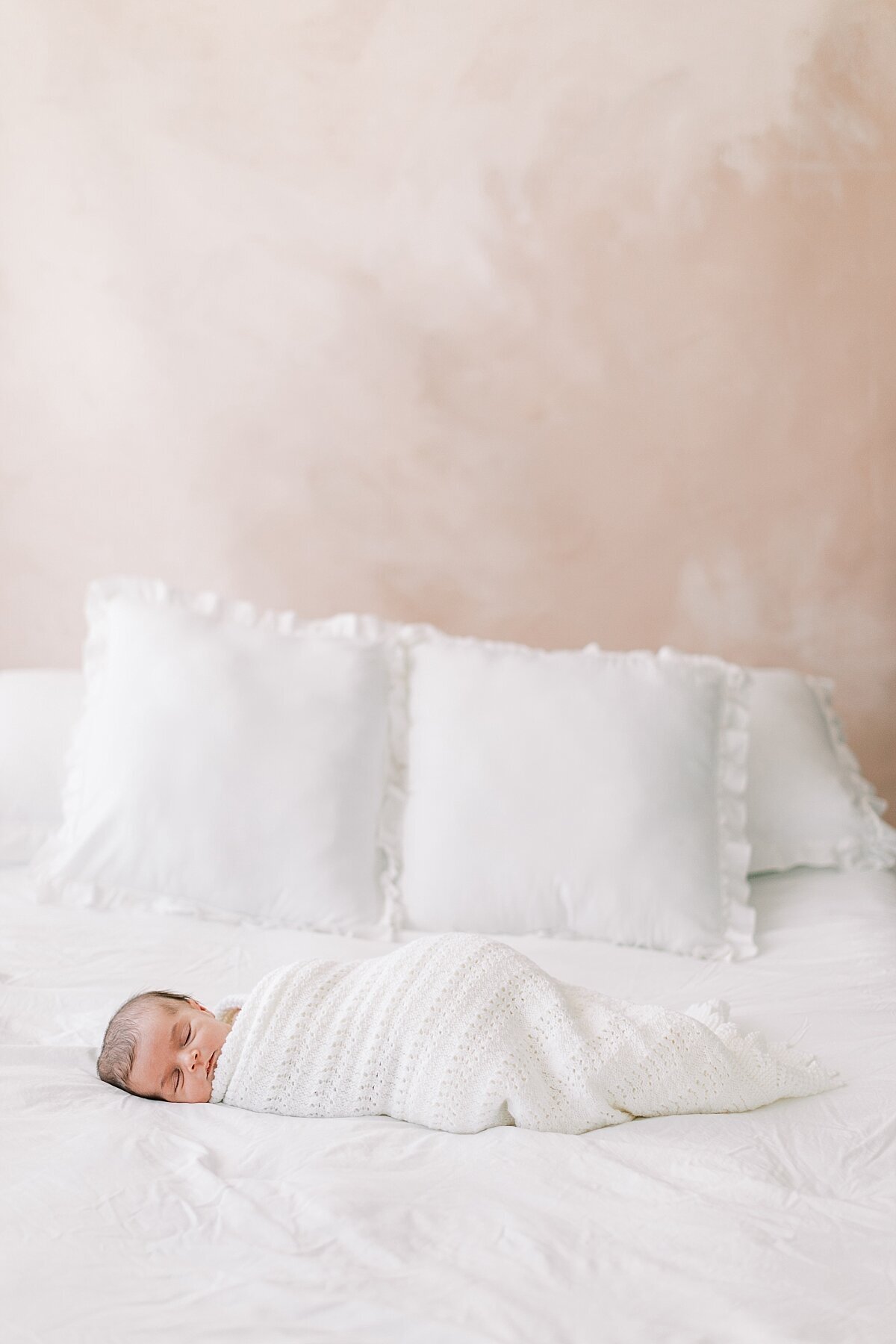 newborn girl wrapped in white blanket