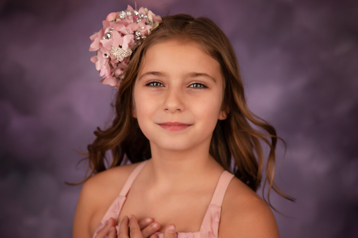 tween-in-studio-closeup-with-pink-floral-headband-and-wind-blown-hair-against-a-purple-backdrop-arlington-tx