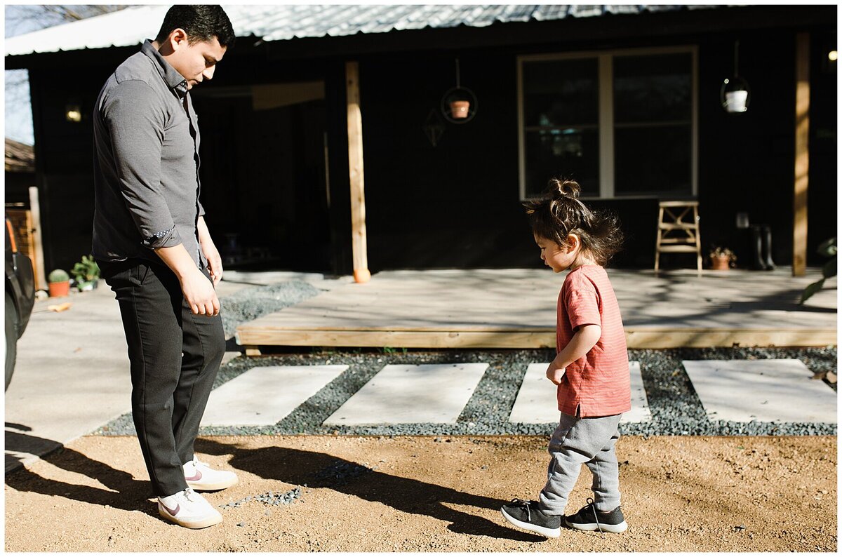 Father watching child walk towards him at  garden family session in Austin by Amber Vickery Photography