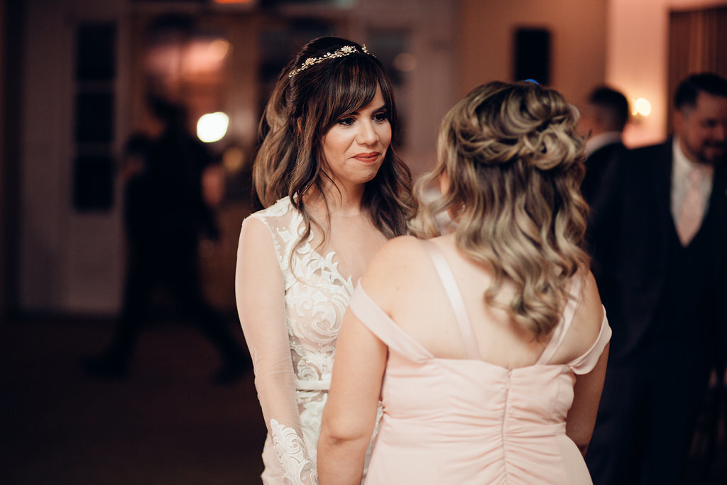 Wedding Photograph Of Bride And Woman In Peach Dress Staring At Each Other Los Angeles