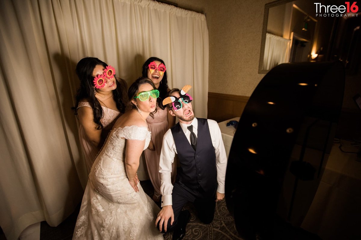 Bride, Groom and Bridesmaids ham it up with the photo booth