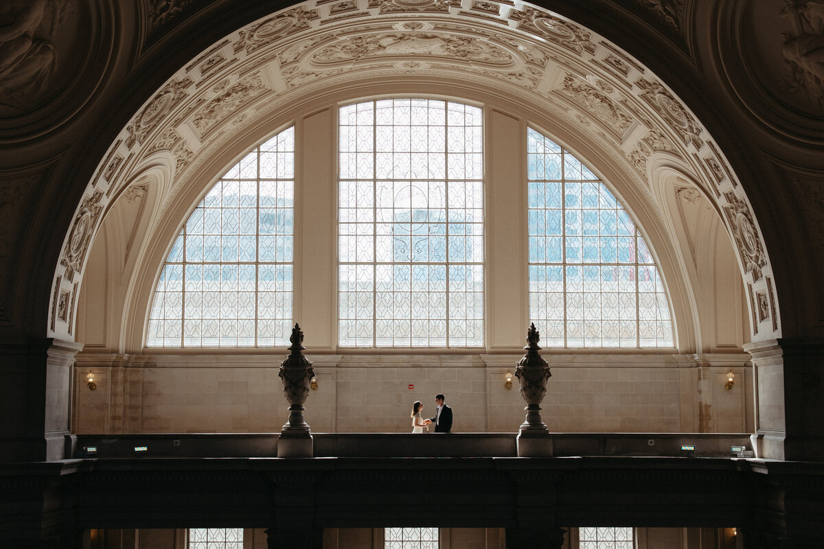 Couple poses on 4th floor of San Francisco City hall on Wedding day