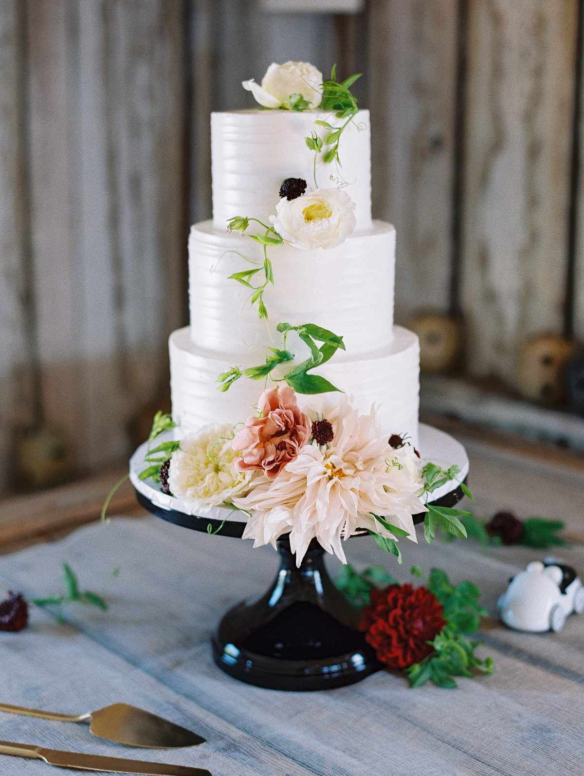 Summer wedding cake with buttercream and dahlia black cake stand © Bonnie Sen Photography