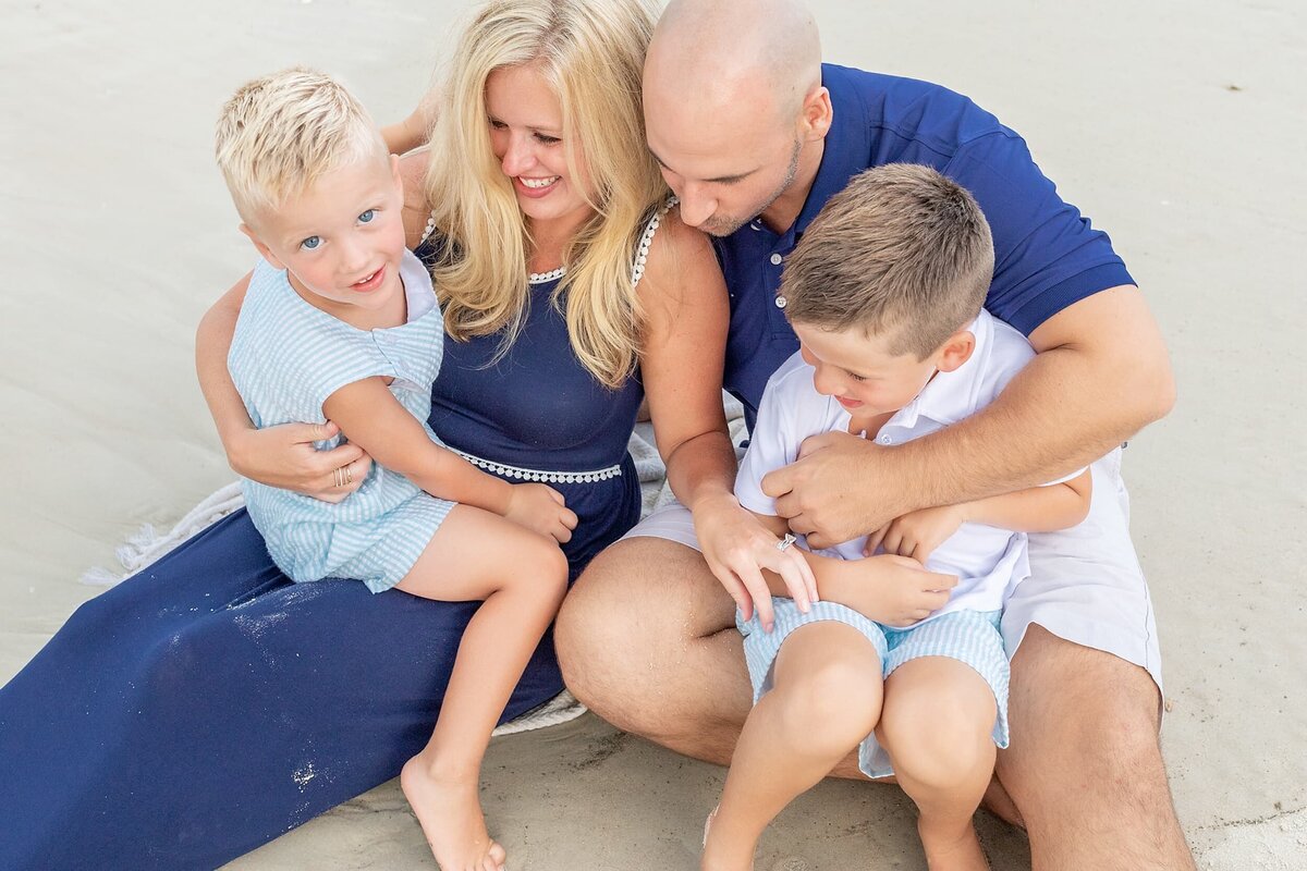 Parents tickling their kids on the beach