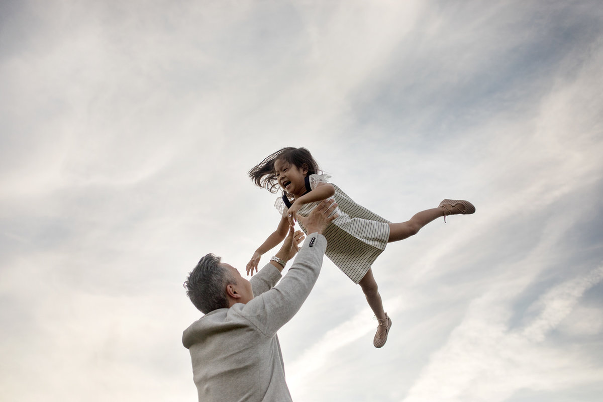 Father holding his daughter up in the air laughing, photo by Elle Baker Photography