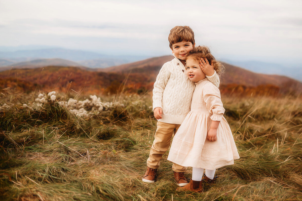 Siblings embrace for photos during Family Portrait Session at Max Patch outside of Asheville, NC.