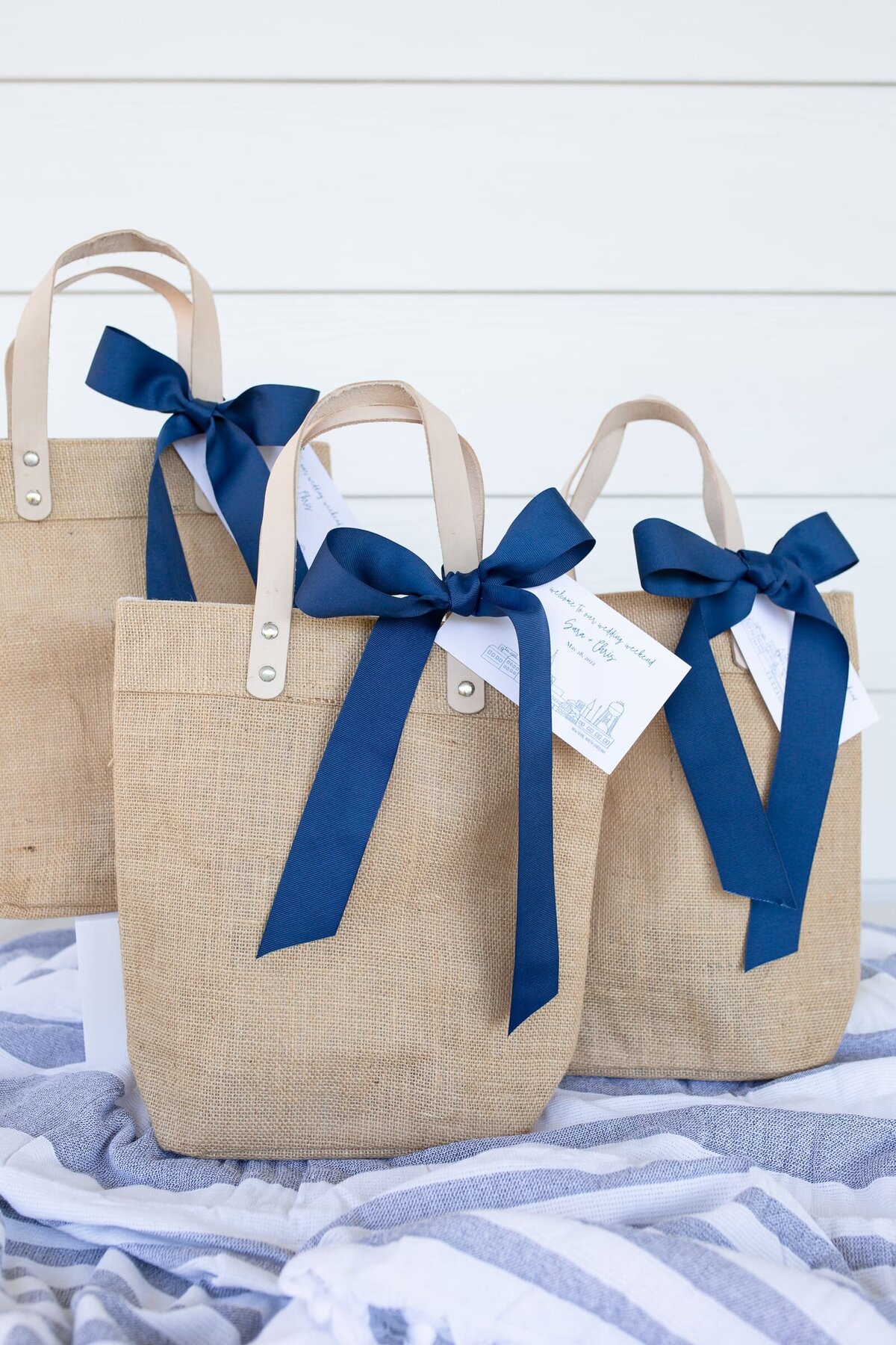 Chapel Hill NC product photographer. Photos of merchendise for website. Tan bags with blue ribbons.