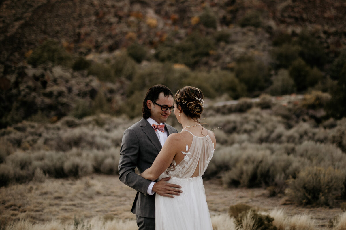 bride and groom holding each other after a first look in the desert