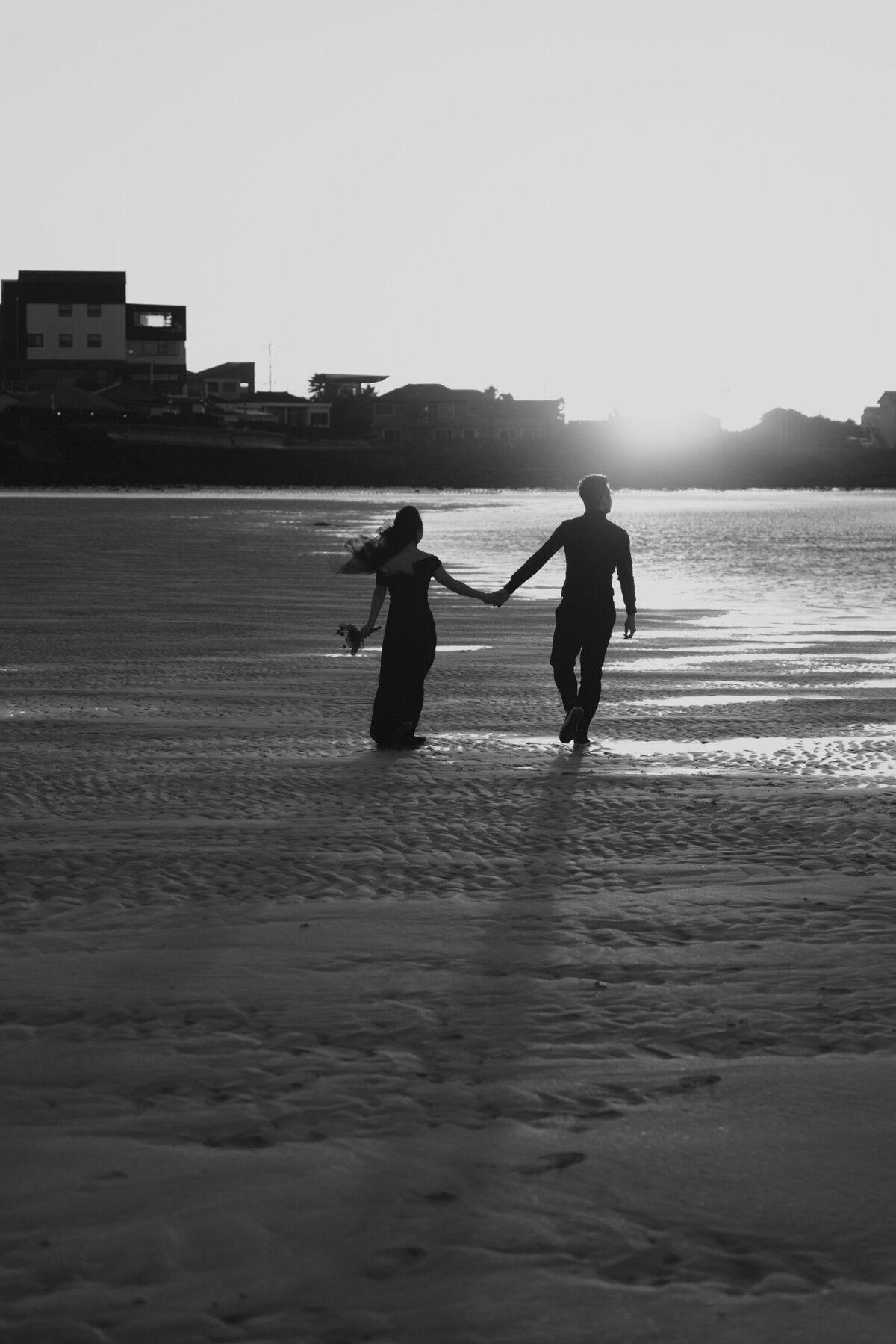the couple walking and admiring the sea while holding hands