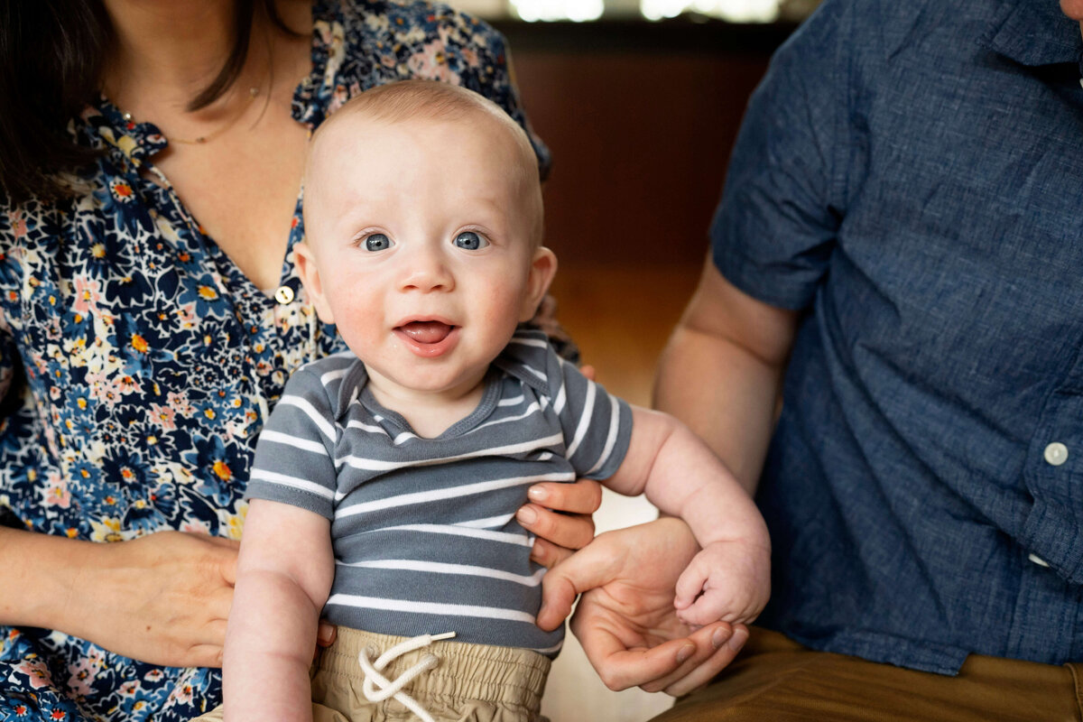 6 month old boy smiling at camera.
