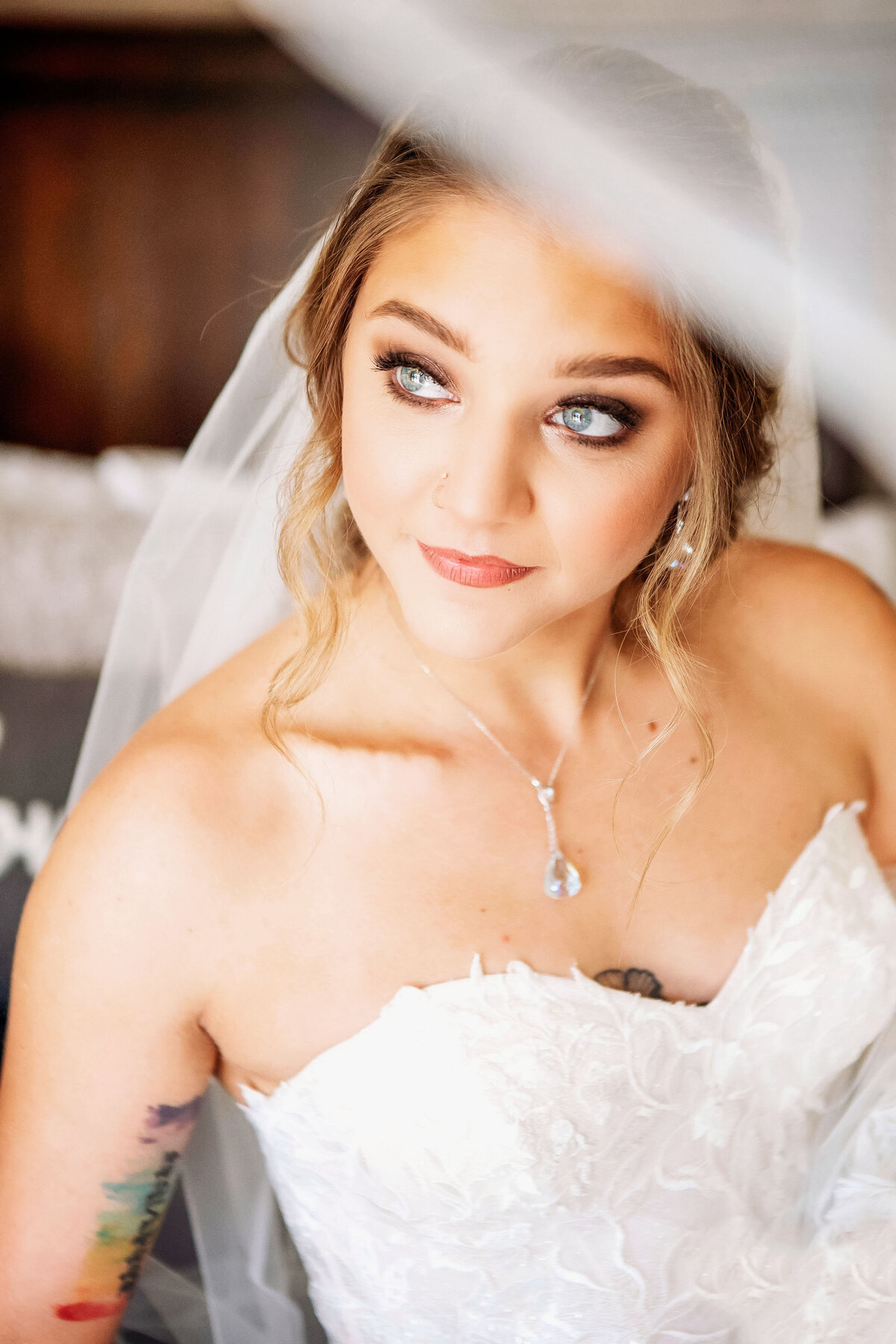 A bride glances up for a moment, as her bright blue gorgeous eyes shine brightly,