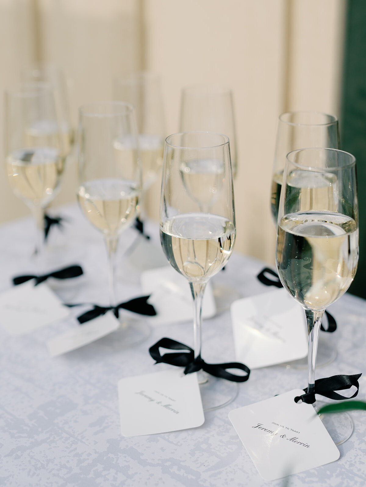 champagne flutes with black ribbon and personalized tags ready for the ceremony