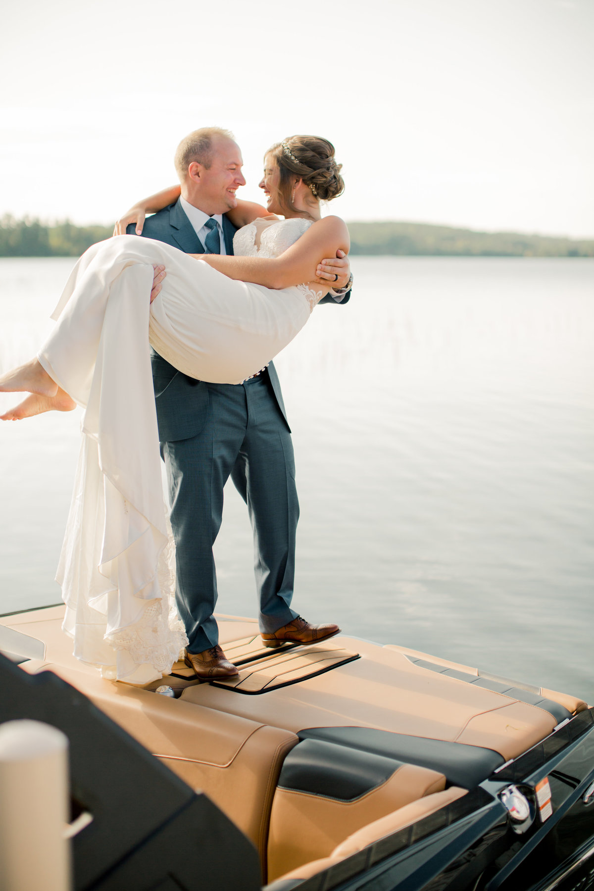 crossing the threshold of the dock to boat carried by new husband gull lake minnesota