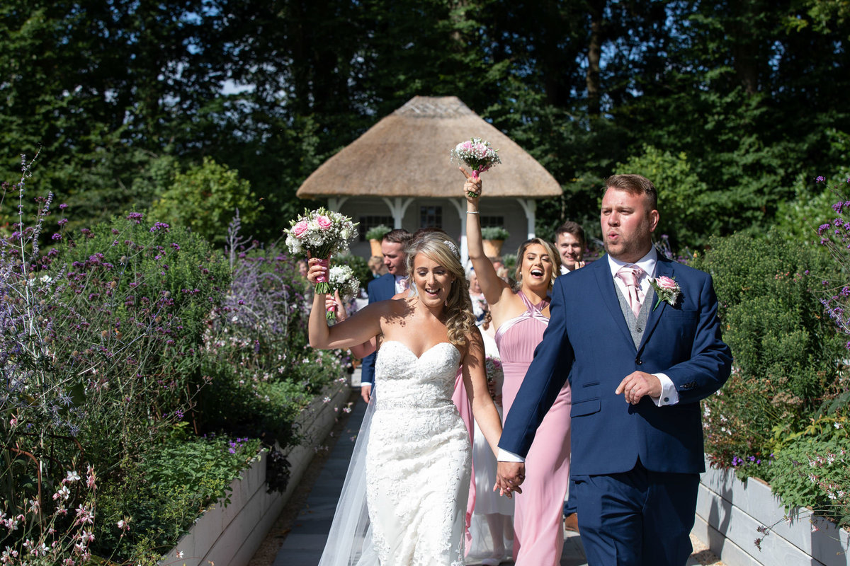 Bride and Groom dancing down the aisle after their outdoor Deer Park wedding in Devon