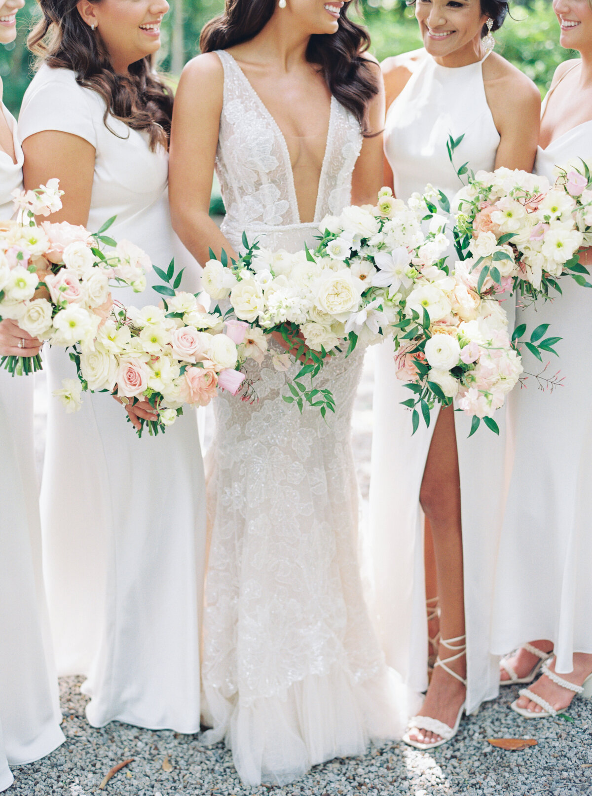 Bridesmaids in white dresses with a different cut. White flowers with touches of pale pink.