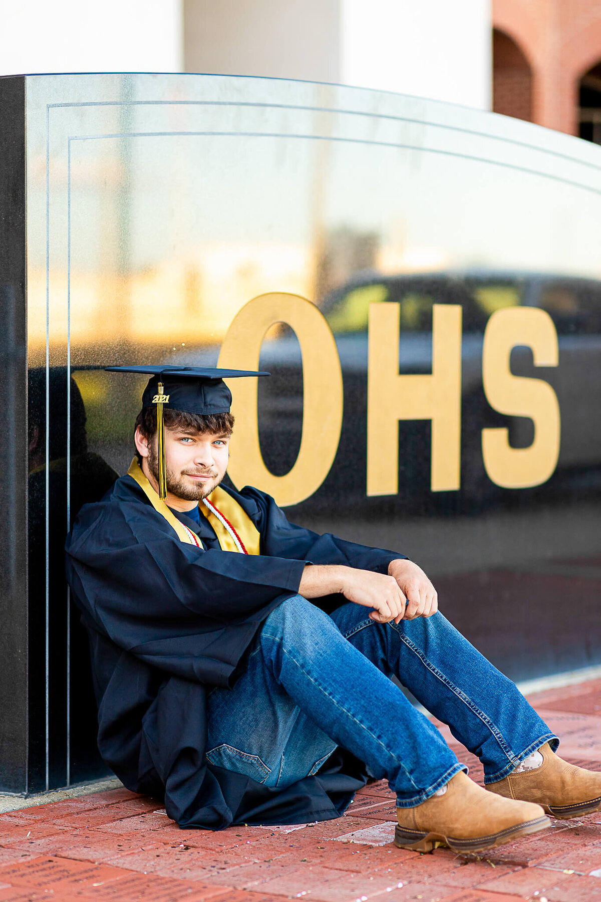 High school senior male in his cap and gown at his high school