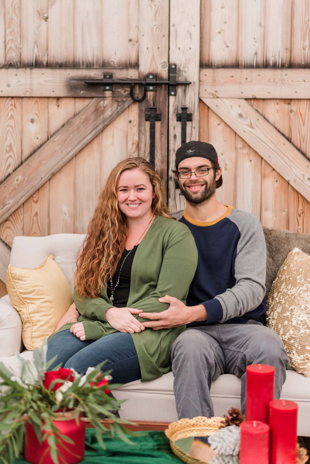 Couple sitting next to each other on  a couch for christmas photos