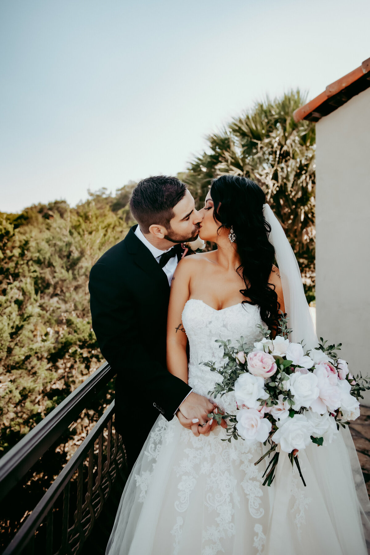 Couples Photography, bride and groom kiss outside in estate on the hillside