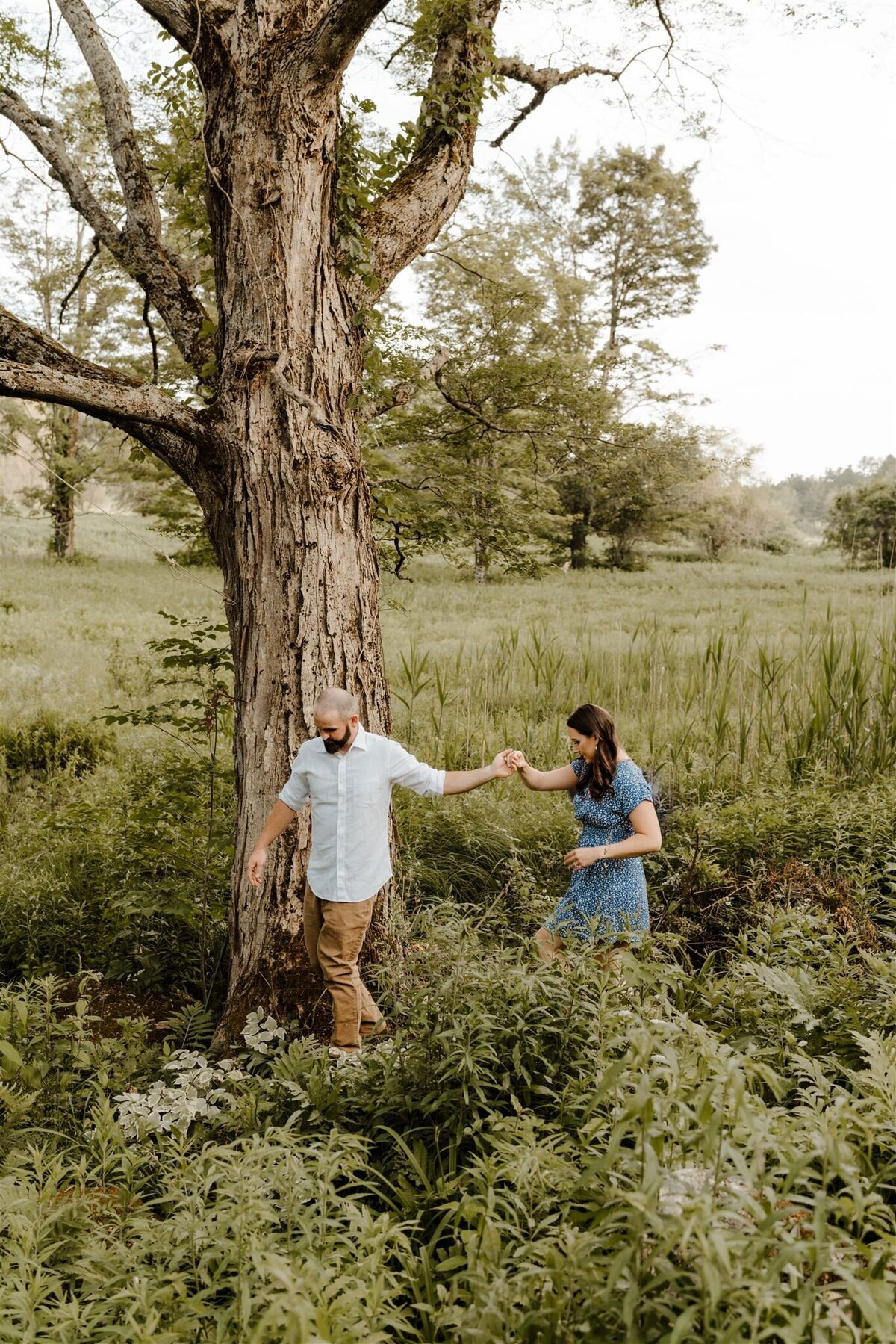 couple holding hands during forest themed engagement photos