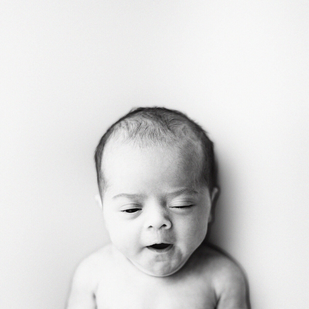 black and white image of baby yawning