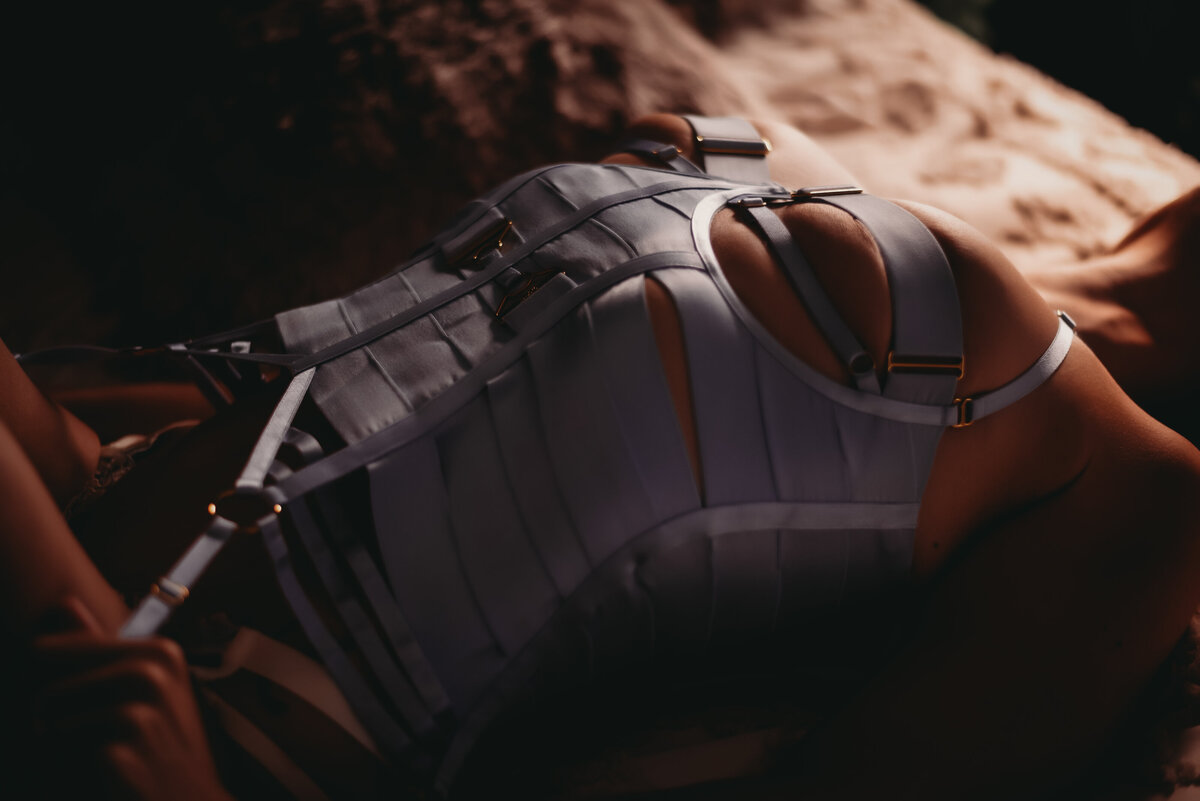 woman laying on bed in baby blue strap lingerie