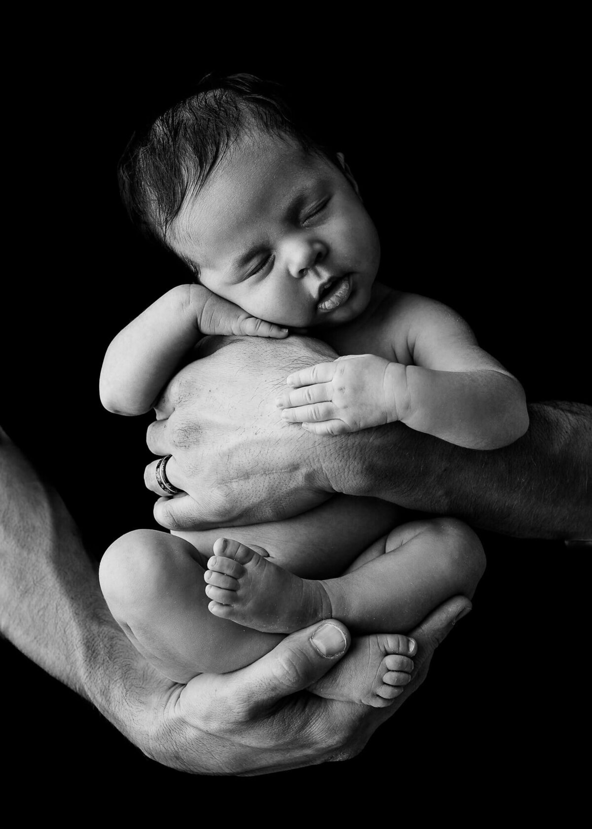 baby girl in dads hands, black and white newborn picture