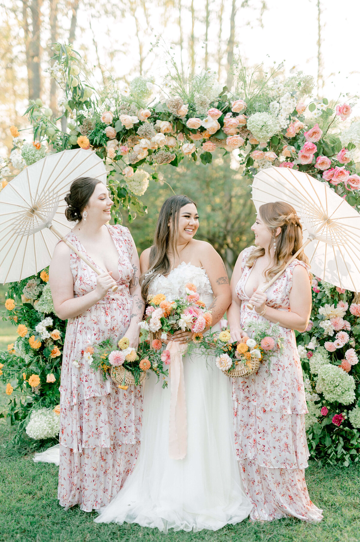Joyful image of a bride and her bridesmaids laughing at one another at a peach inspired wedding at Larz Anderson House
