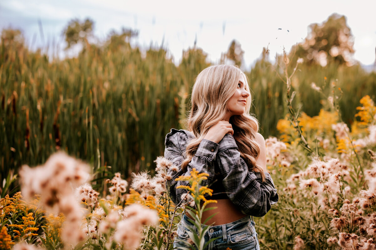 girl stands in flower fields for senior phtoos in thornton colorado