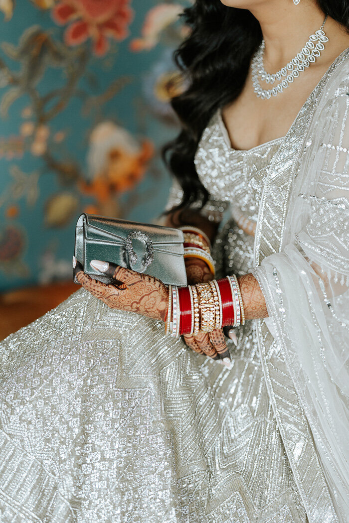 Bride in her wedding gown with accessories and henna tattoos.