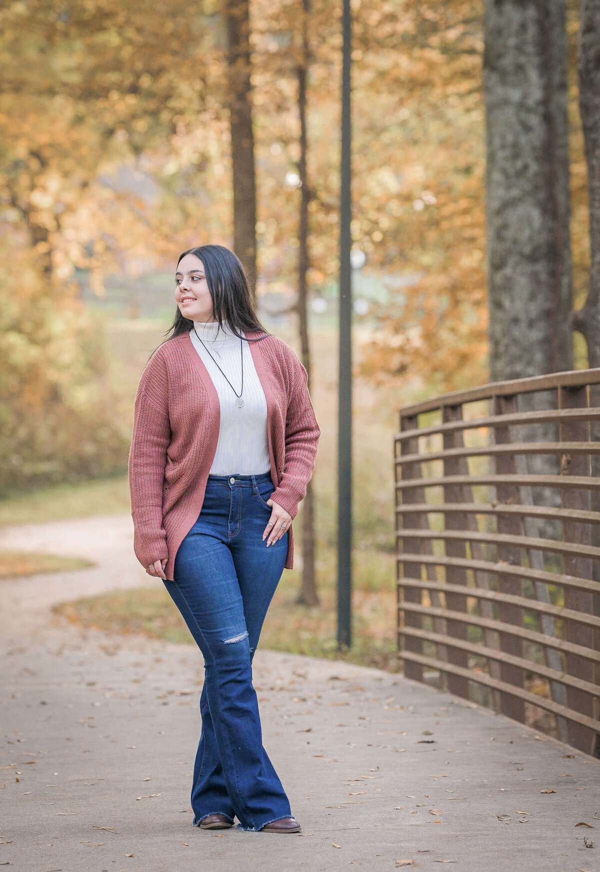 girl walking by a bridge at Logan Farm Park during her senior photo session by Elizabeth Klusmann Photography