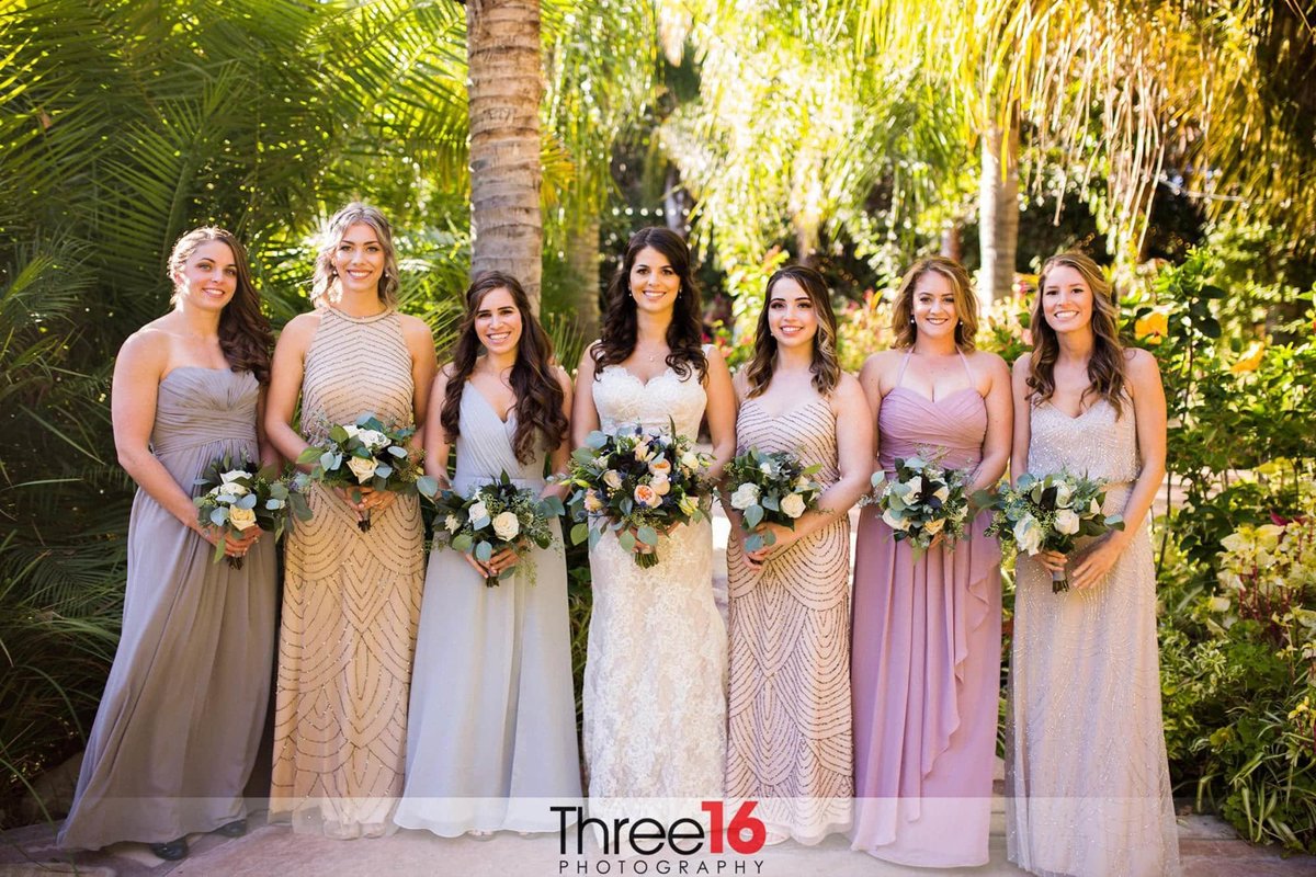 Bride and her Bridesmaids wear different color gowns pose for pictures