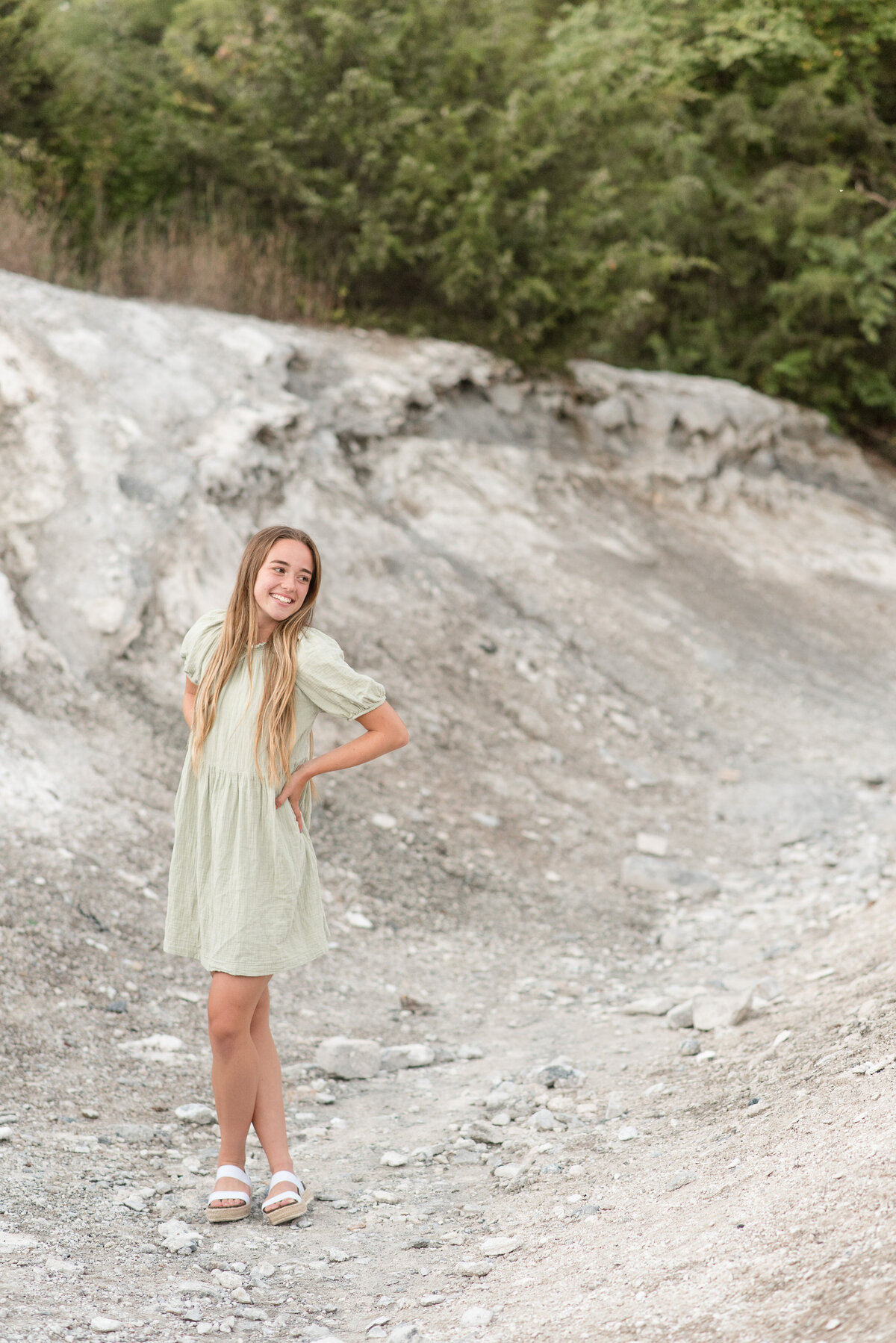 Senior girl with hands on hips and left ankle over right ankle leaning slightly back at the White Cliffs of Canoy in Lancaster, Pennsylvania.