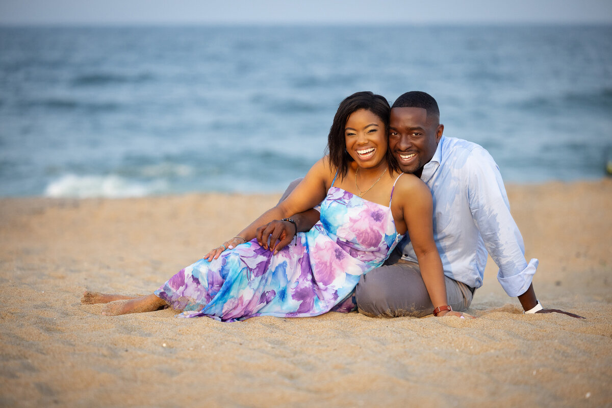 engaged-couple-sitting-beach-asbury-park