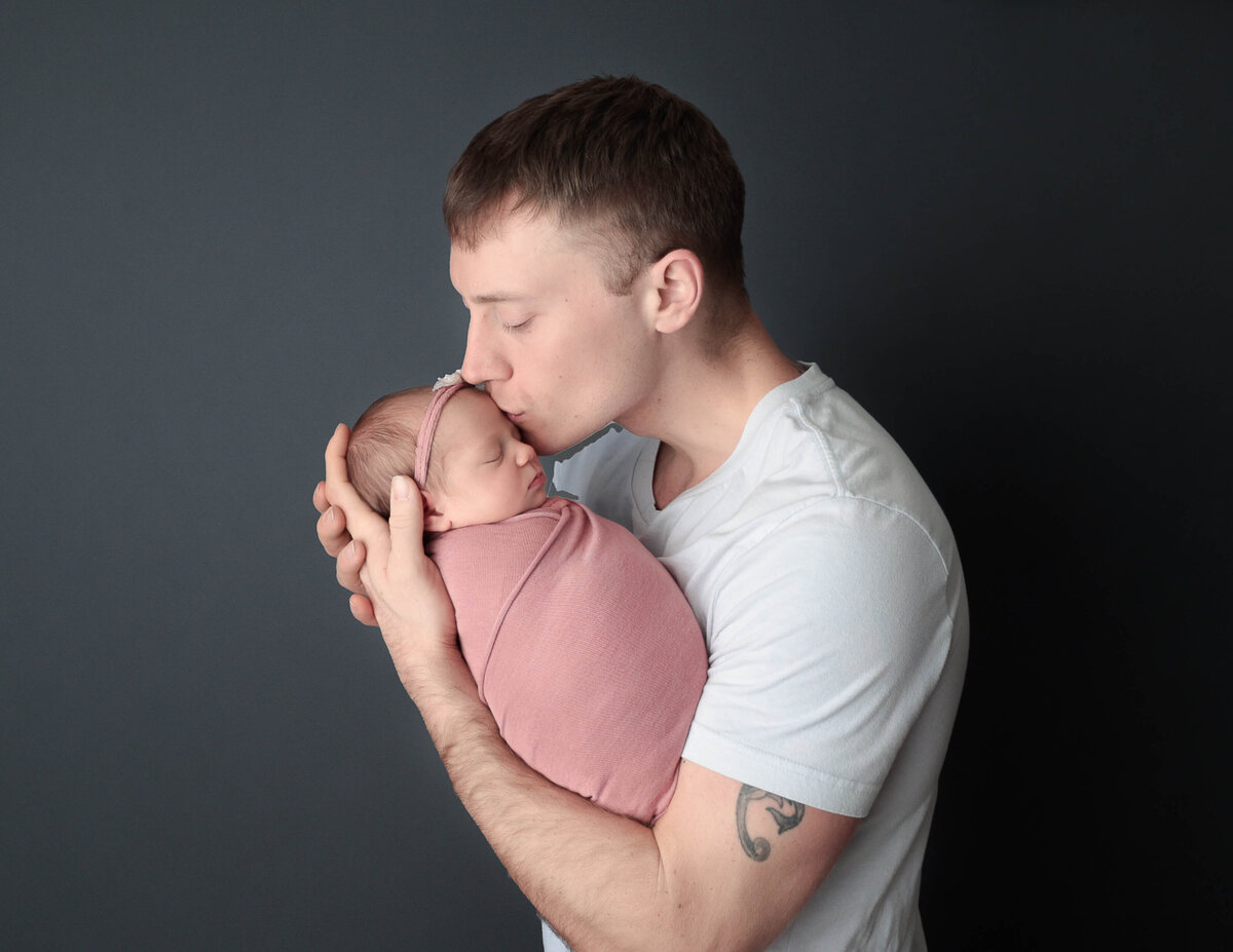 Dad kissing newborn daughter, Rochester, Ny.