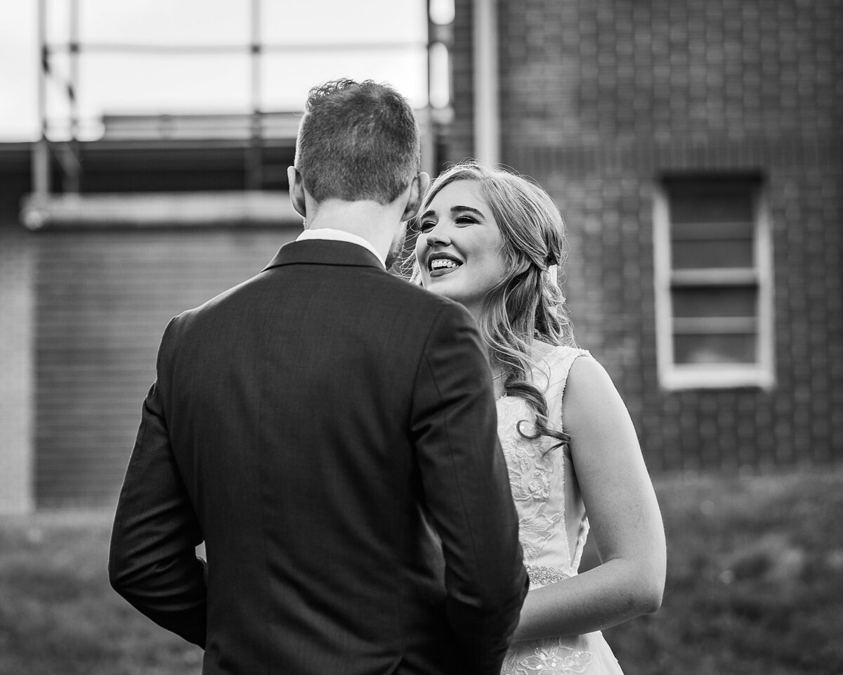 black and white image of bride looking at groom