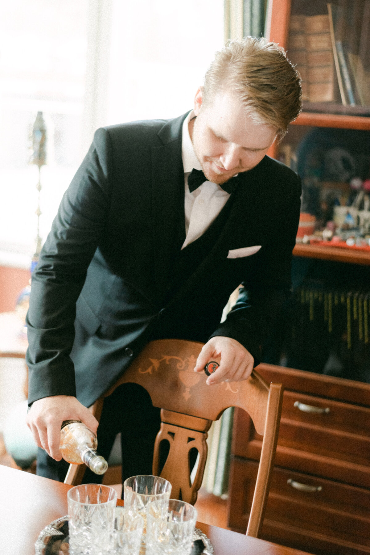 The groom is serving wisky in an image captured by wedding photographer Hannika Gabrielsson.