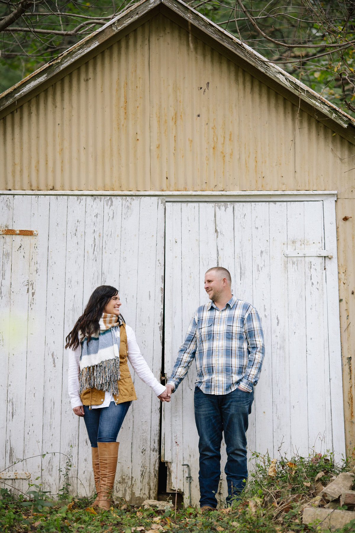 engaged couple stand by barn at bayonet farm