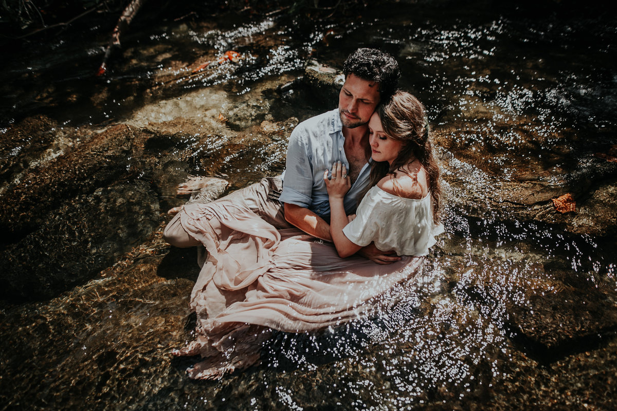 Couple snuggling in river after their elopement in Asheville
