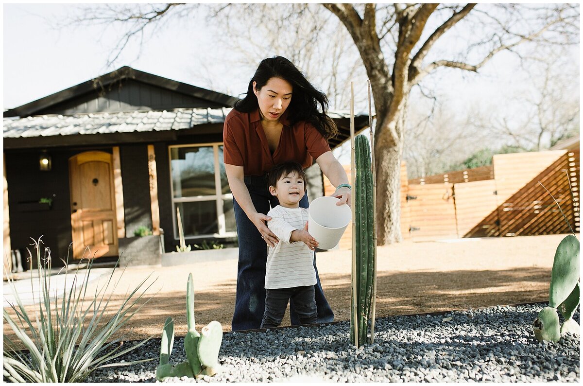 Mother with child helping him water a plant at  garden family session in Austin by Amber Vickery Photography