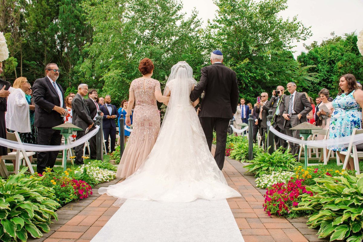 Outdoor wedding ceremony, bride walking down the aisle