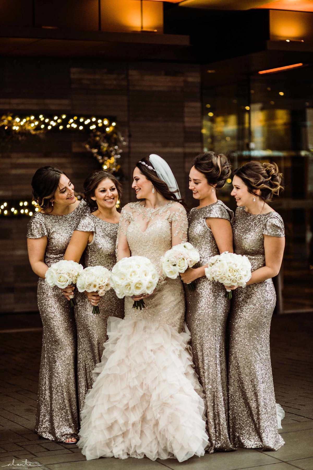Glamorous bride and her bridesmaids dressed in champagne sequin dresses.