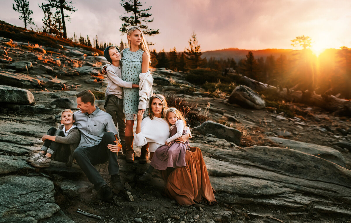 Family of six snuggling on a mountain at Yosemite.