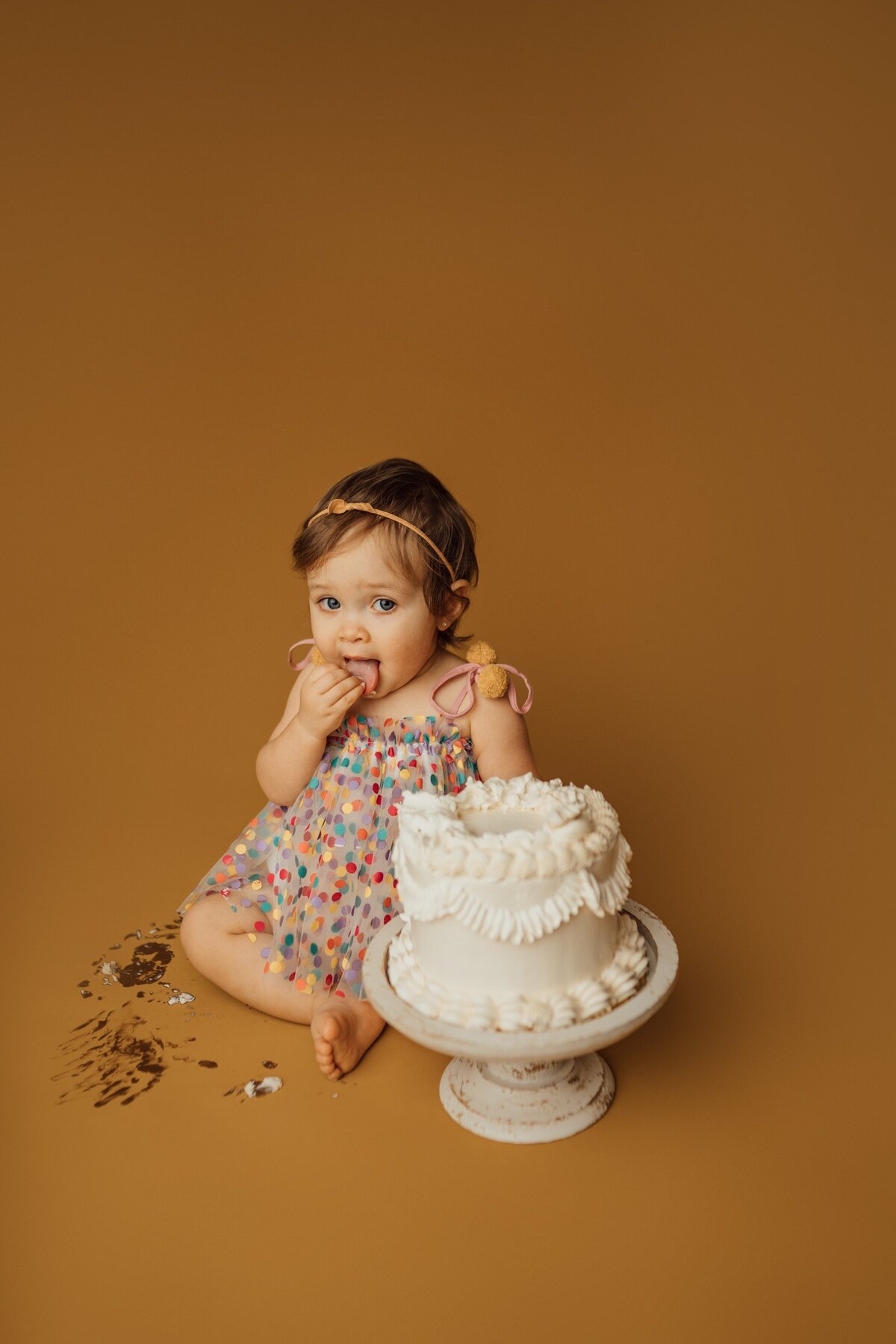 girl eating cake during cake smash photography session in Tampa, FL