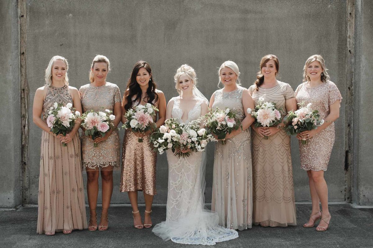 We love the look of bridesmaids all dressed in a unique champagne colored dress and holding cafe au lait dahlia bouquets!