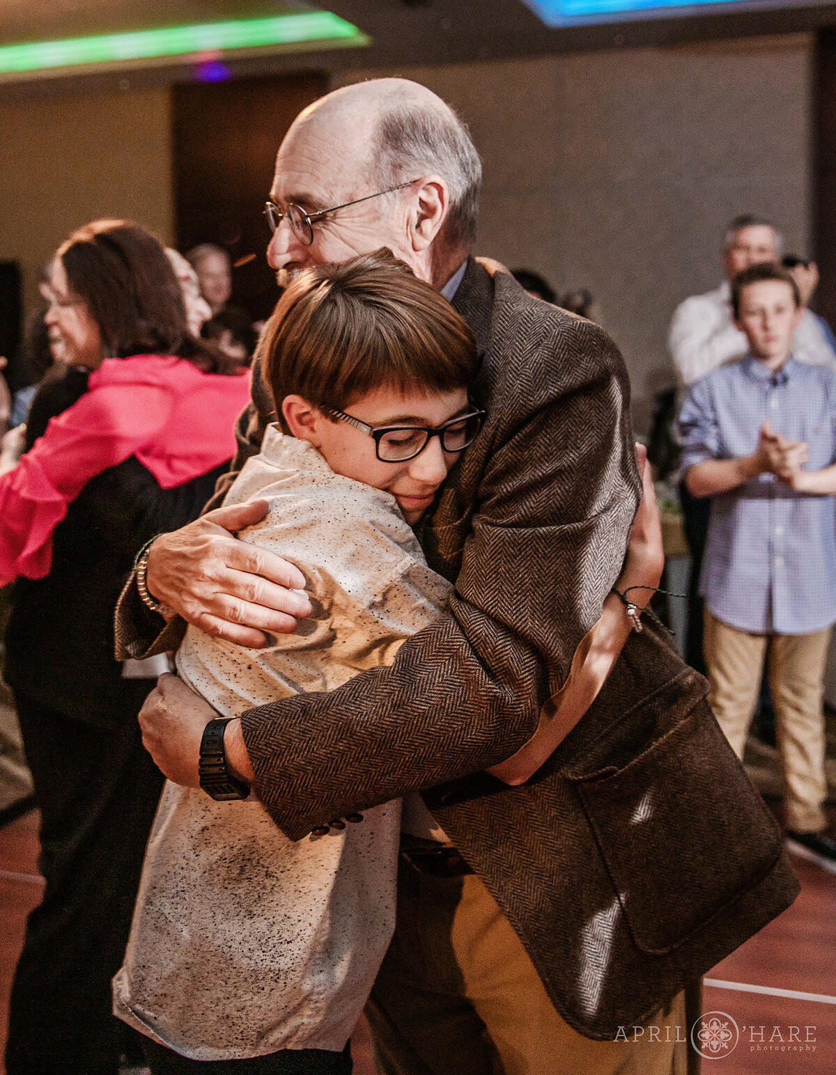 Grandfather hugs his grandson at his Bar Mitzvah Party in Colorado