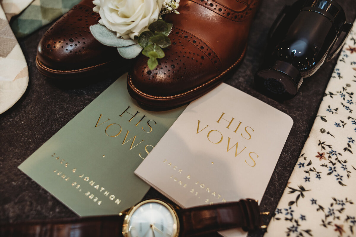 Grooms' wedding details with brown leather shoes, sage green ties, and vow books at a Mountain Sage Wedding at Camelot Ranch.