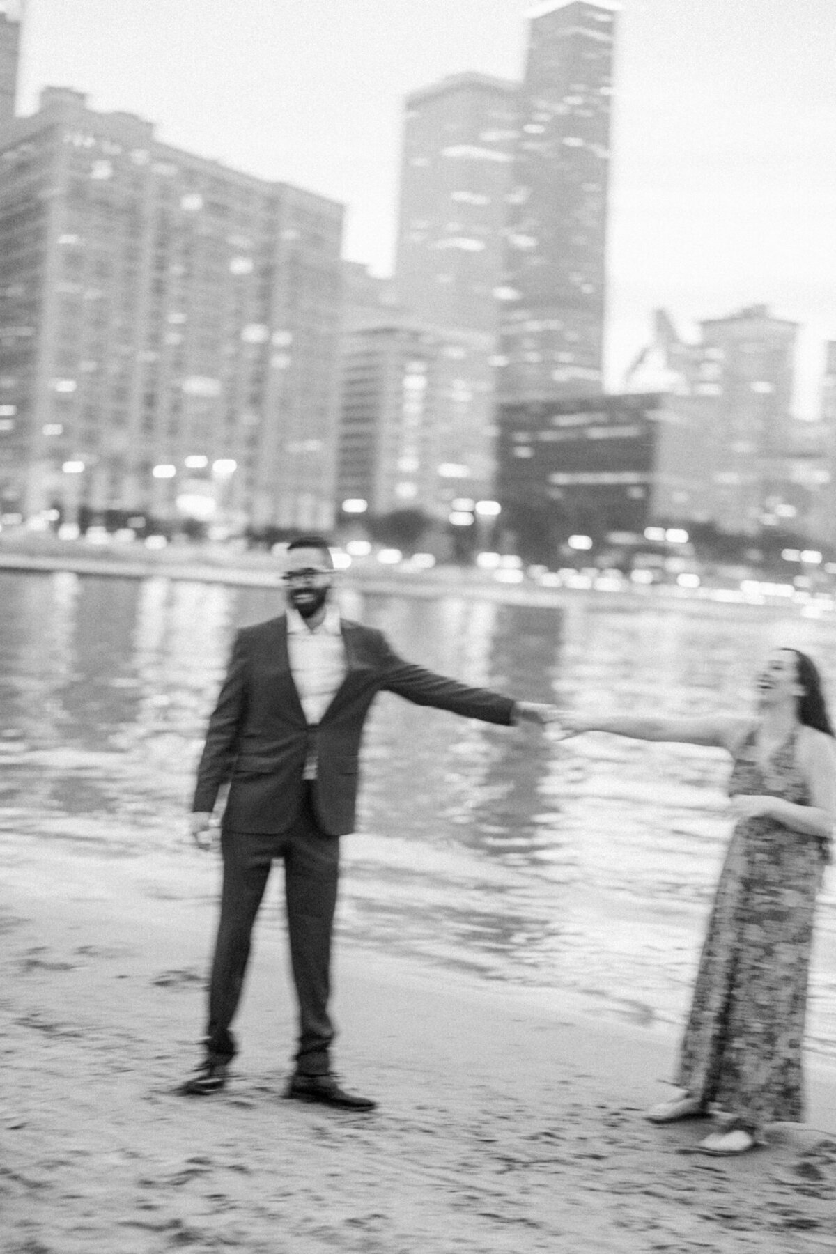 A blurry, black and white engagement photo that shows movement and joy