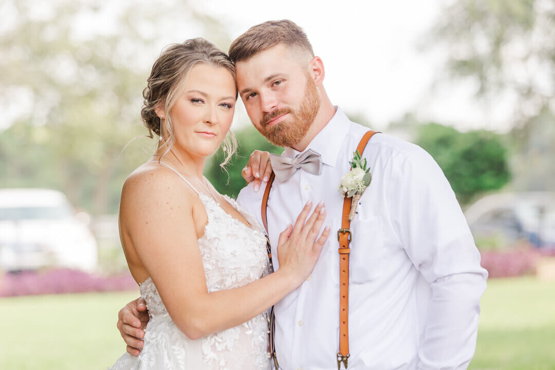 Up close photo of bride and groom embracing and smiling at the camera at Red Gate Farms. Captured by Arkansas wedding photographer Photography by Karla.