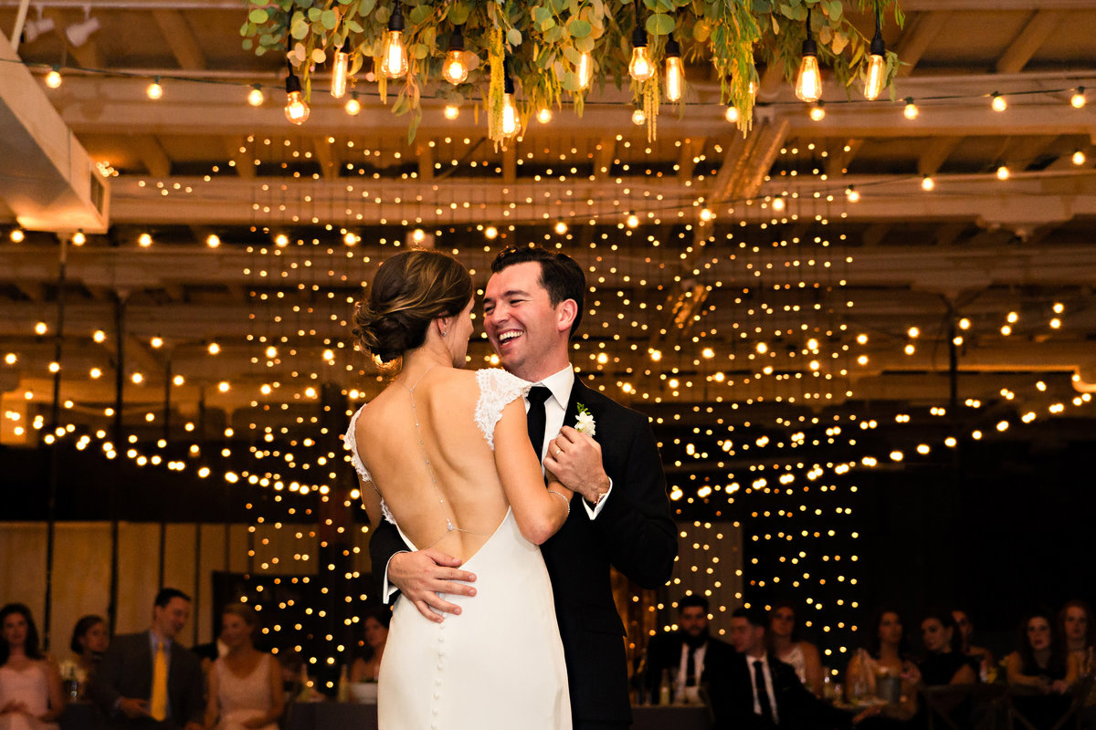 The bride and groom share their first dance under twinkle lights at their Portland Maine wedding